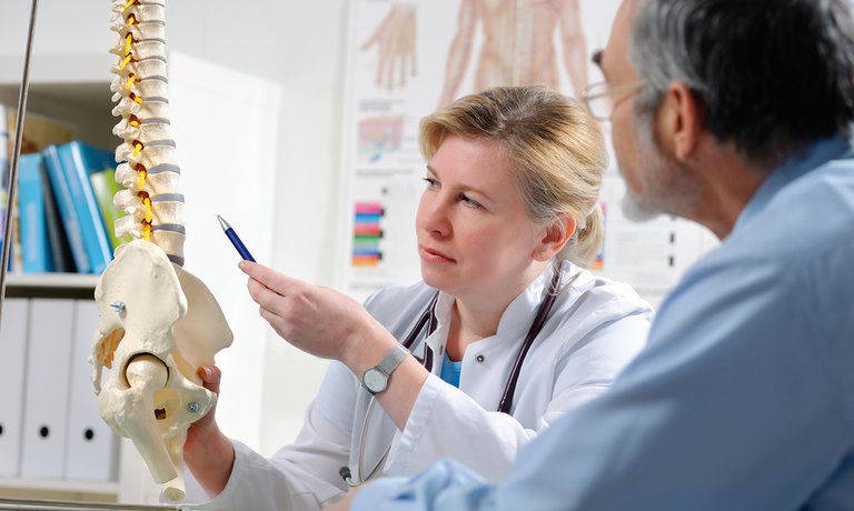 Medic explicând pacientului o posibilă compliacație a BCR - boala osoasă metabolică