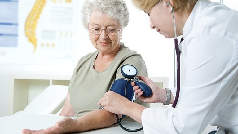 Doctor luând presiunea sangvină a unei femei